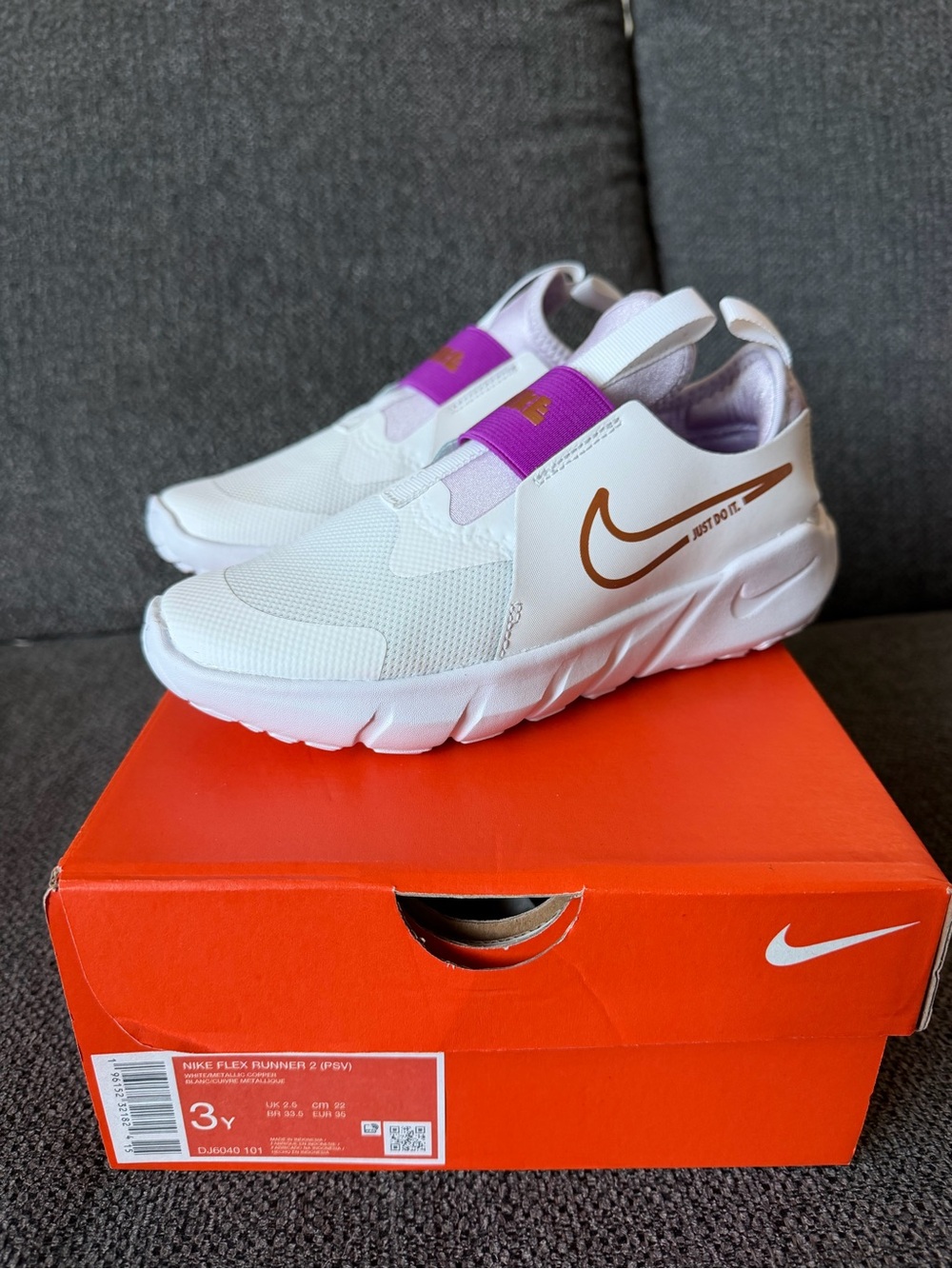 Nike White Kids Slip-On Sneakers with Purple Strap and Gold Swoosh